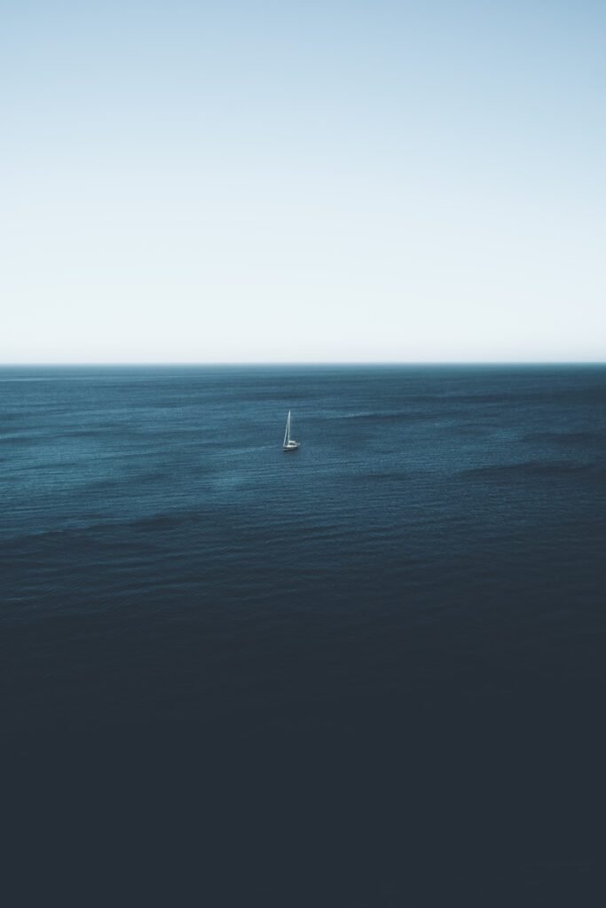 Osamělá plachetnice na širém moři – symbol svobody a připojení díky Starlink internetu.